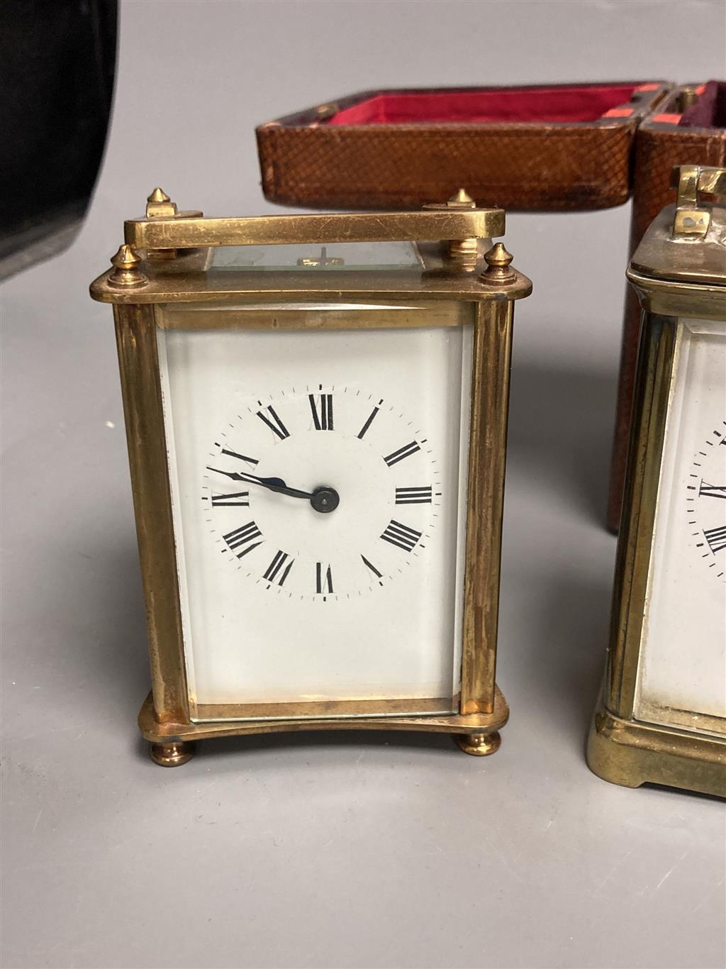 Three small gilt brass carriage timepieces, one with leather outer case, largest 10.5cm high